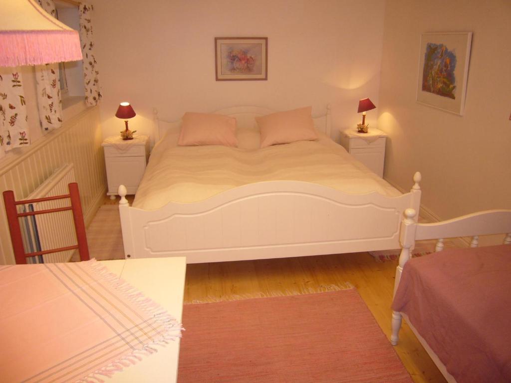 Ransäter普瑞斯特雷恩旅舍的卧室配有一张白色床、两张桌子和两盏灯。