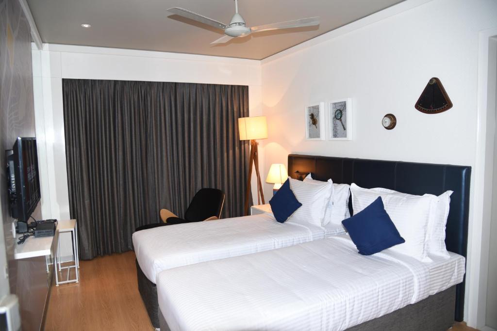 维沙卡帕特南The Port Hotel的酒店客房 - 带两张带蓝色枕头的床