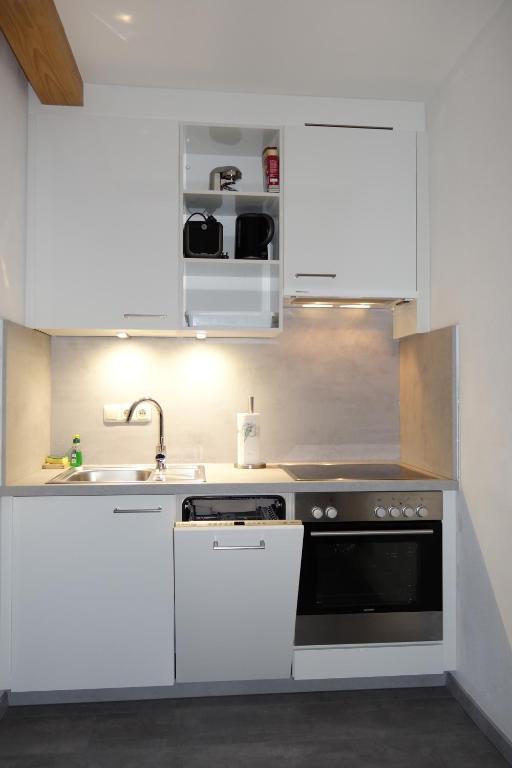 滨湖采尔Landhaus Schmittenblick的厨房配有白色橱柜和水槽