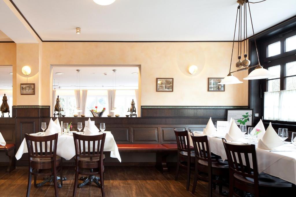 韦默尔斯基兴祖登德雷林登酒店的一间设有白色桌椅的用餐室