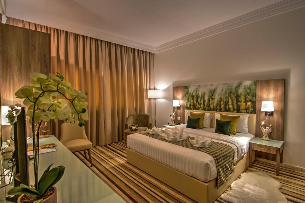 拉斯阿尔卡麦皇家美景酒店的卧室配有一张大床,墙上挂有绘画作品