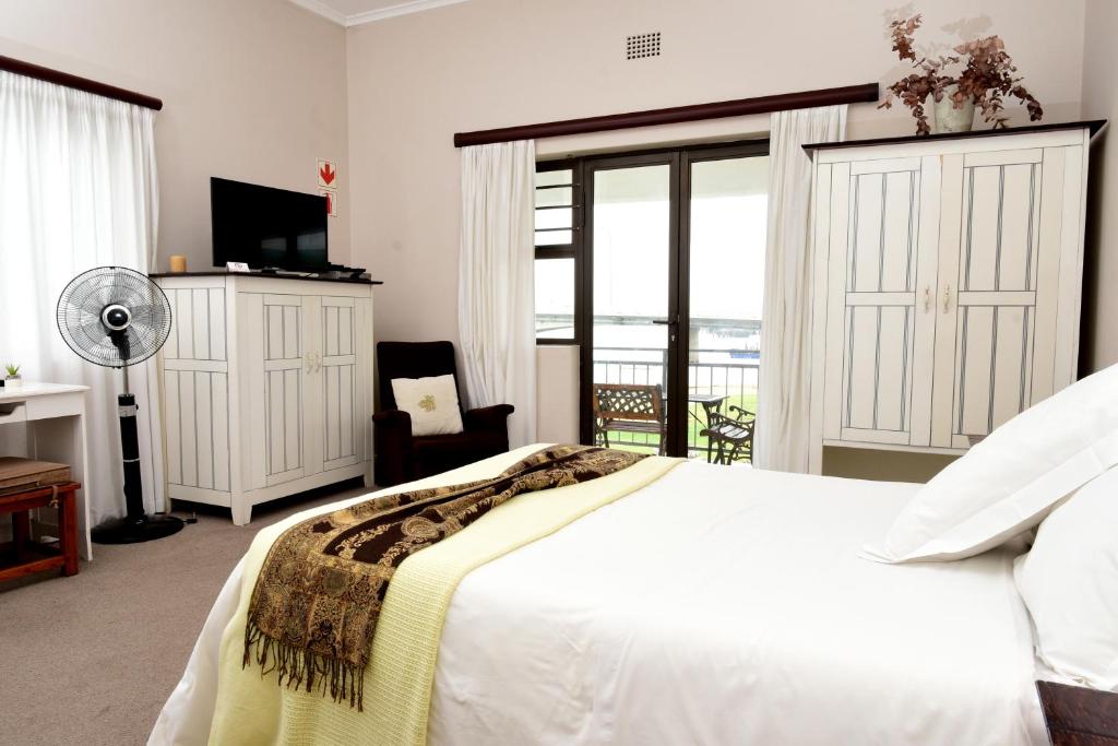 韦尔德里夫Riviera Hotel & Chalets的一间带白色床的卧室和一个阳台