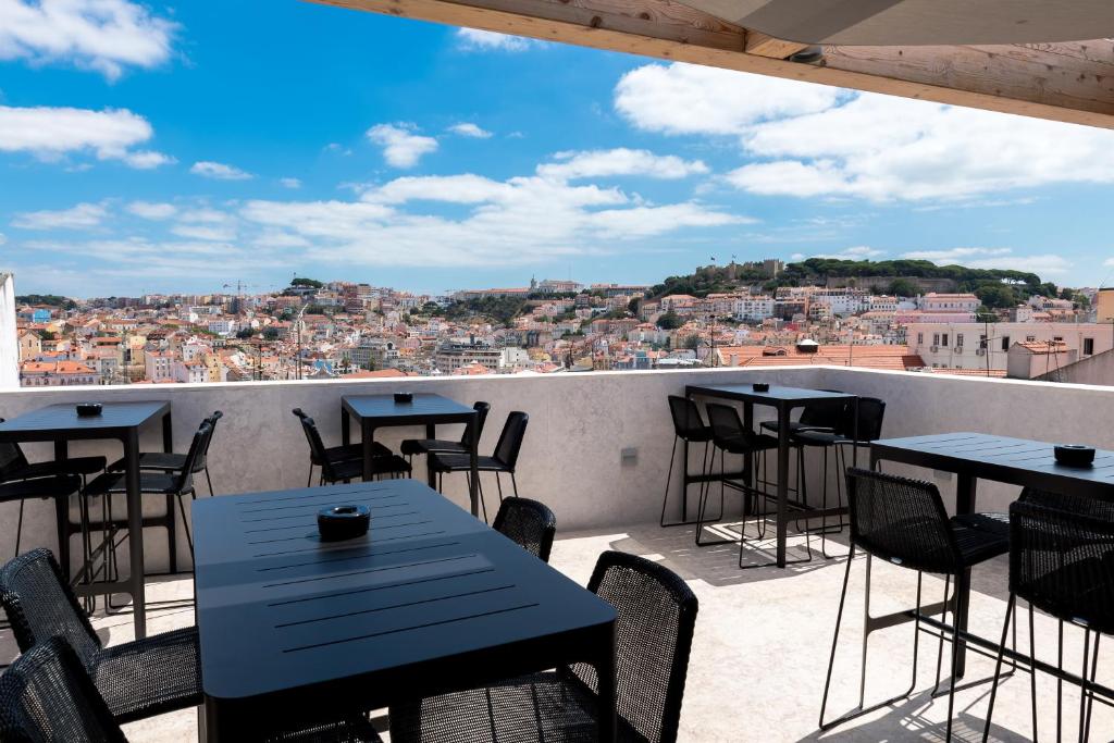 里斯本里斯本佩索阿酒店的一个带桌椅的庭院,享有城市美景