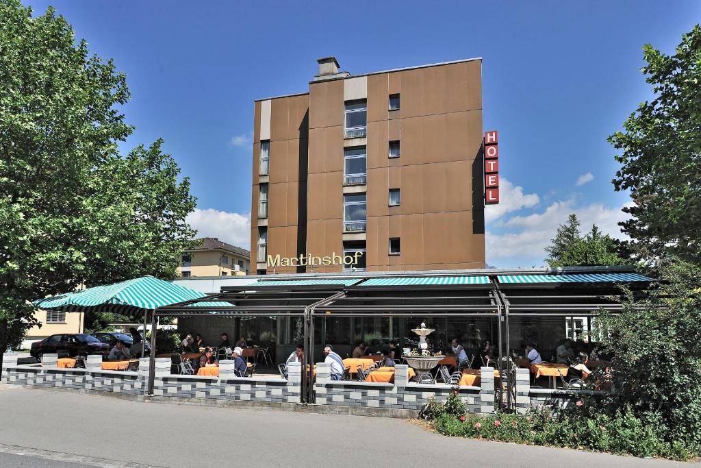 楚赫维尔满婷福酒店的一间餐馆,人们坐在大楼前的桌子上