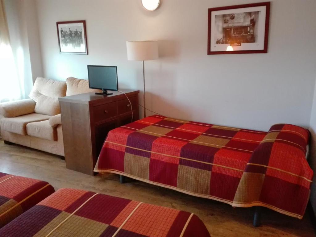 Castañares de Rioja老板旅馆的酒店客房,配有床和沙发