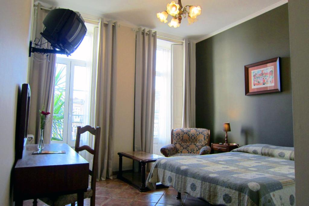 波尔图杜阿斯纳克斯旅馆的卧室配有床、椅子和窗户。