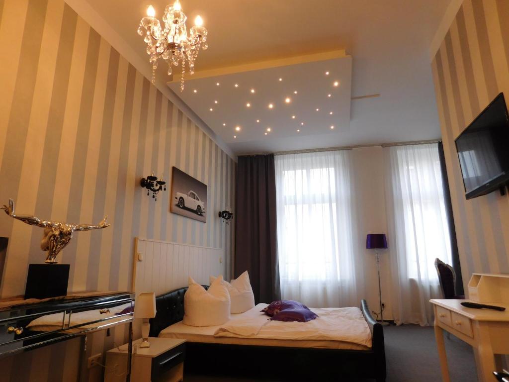 阿尔滕堡Boutiquehotel Mason的酒店客房,配有一张床和吊灯