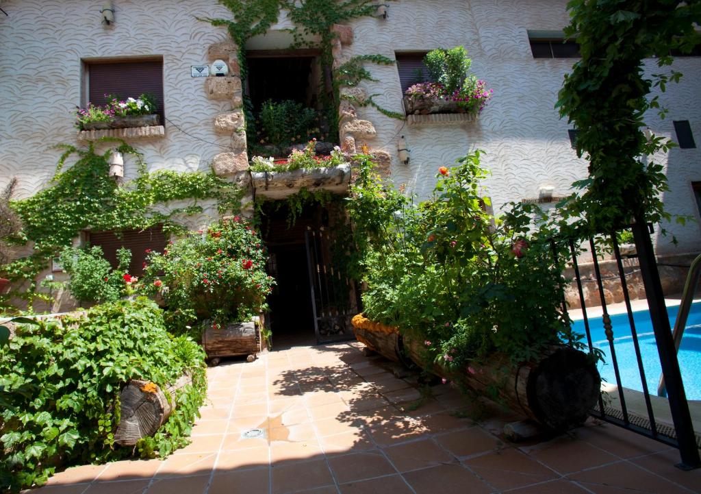 阿罗约弗里奥Casa Rural Capricho del Valle的一座带游泳池、一些植物和围栏的房子