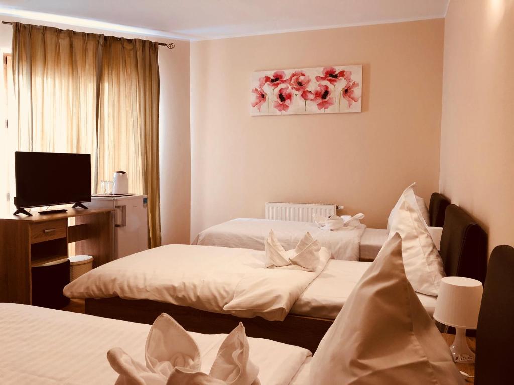 布加勒斯特Monte Carlo Palace Rooms的酒店客房设有两张床和电视。