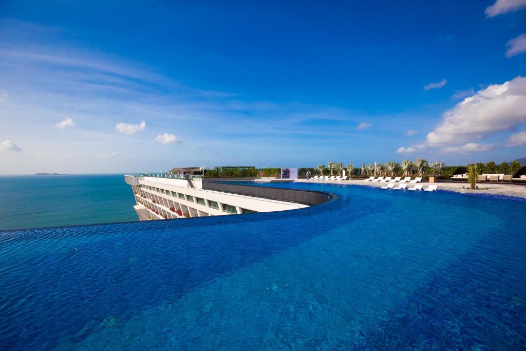 三亚三亚康年酒店的一座背景海洋的游泳池
