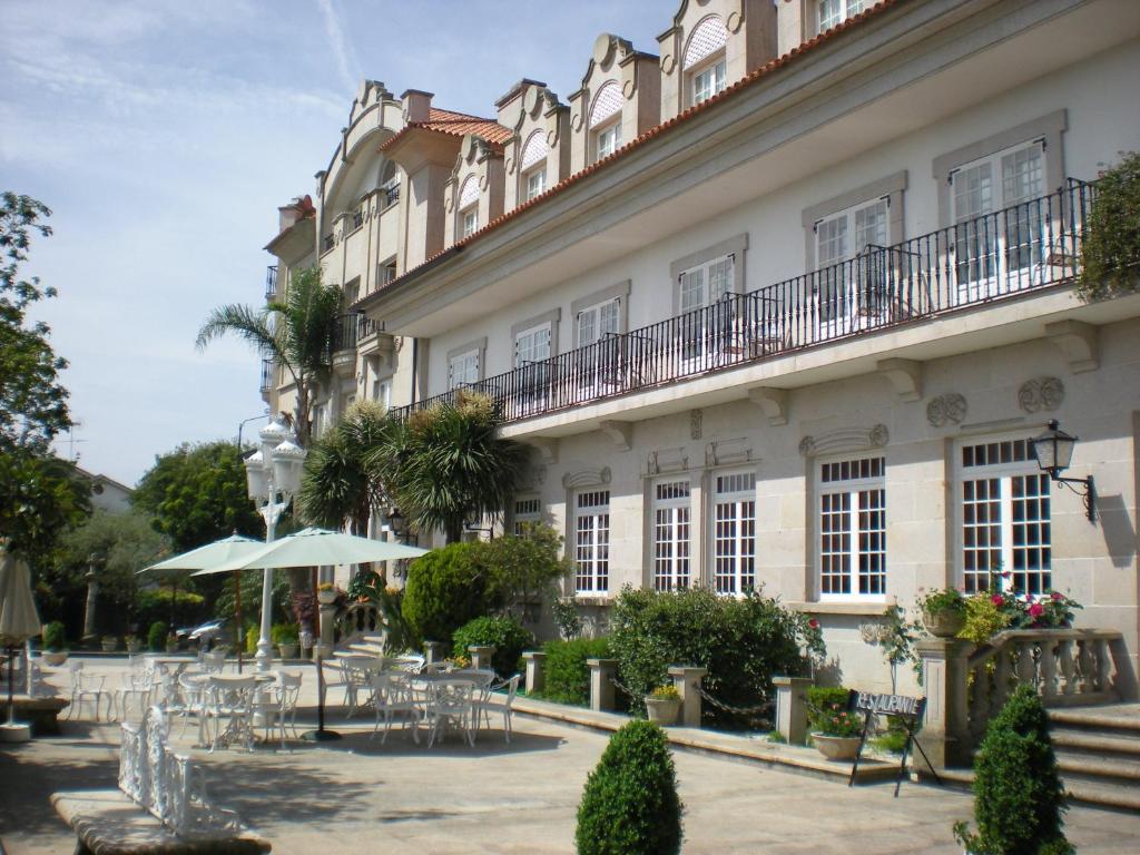 坎巴多斯Hotel - Restaurante Casa Rosita的前面设有桌椅的建筑