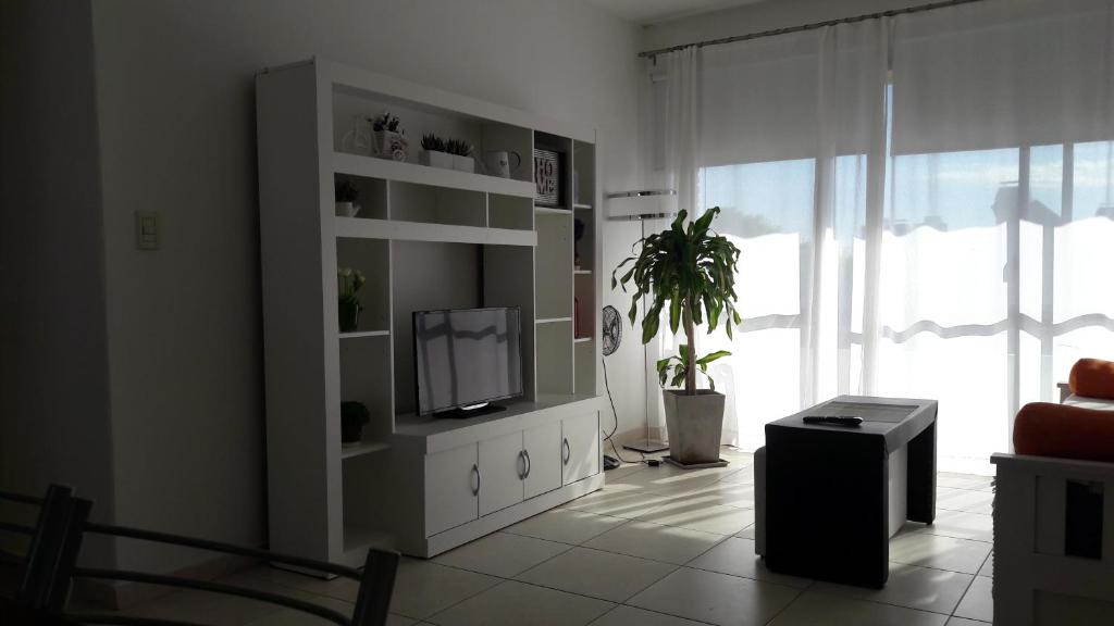 乌拉圭河畔康塞普西翁Apartamento Plaza San Martin的一间客厅,在白色的橱柜上配有电视