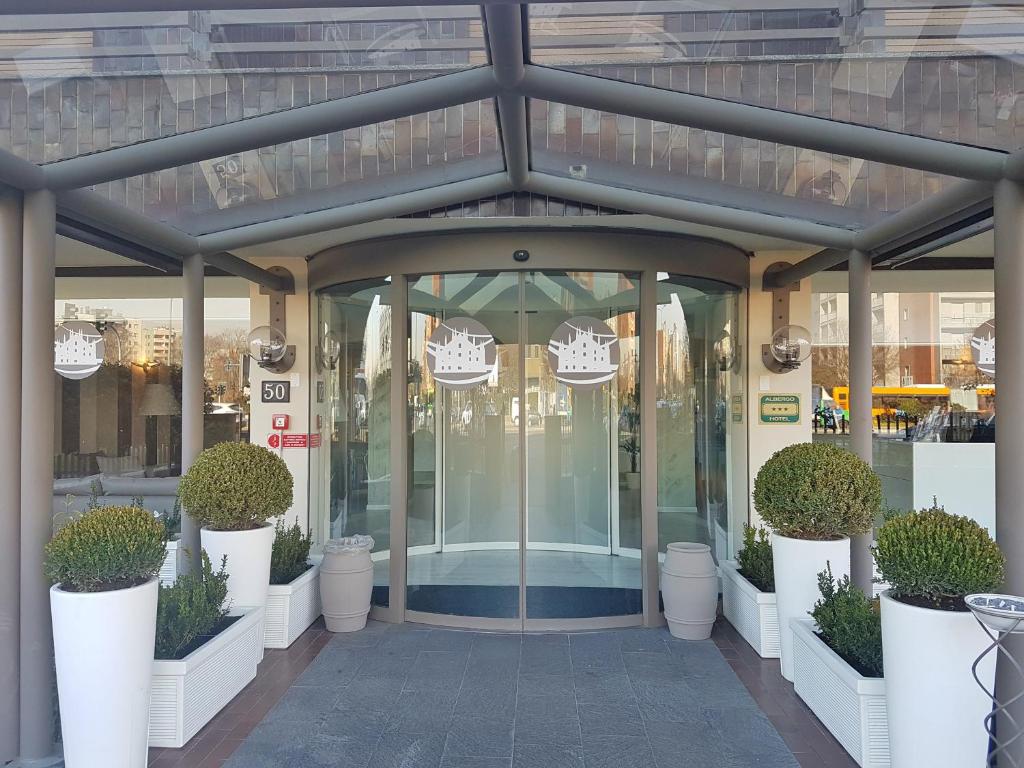 米兰米兰欢迎您酒店的玻璃入口,带盆栽的商店
