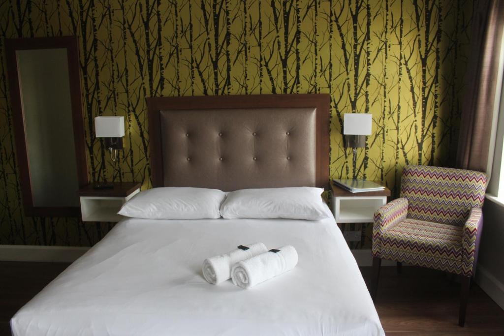 戈尔韦圣茱德斯食宿酒店的床上有两卷卫生纸,带椅子