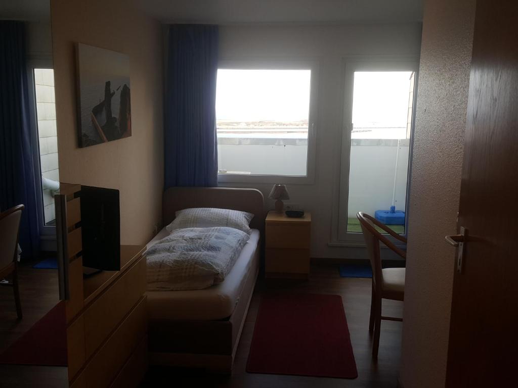 黑尔戈兰岛加尔尼全景酒店的一间小卧室,配有床和2个窗户
