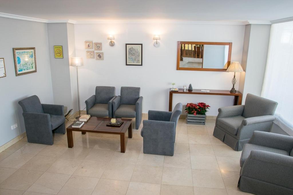 拉科鲁尼亚布里萨酒店的一间设有椅子、桌子和镜子的等候室