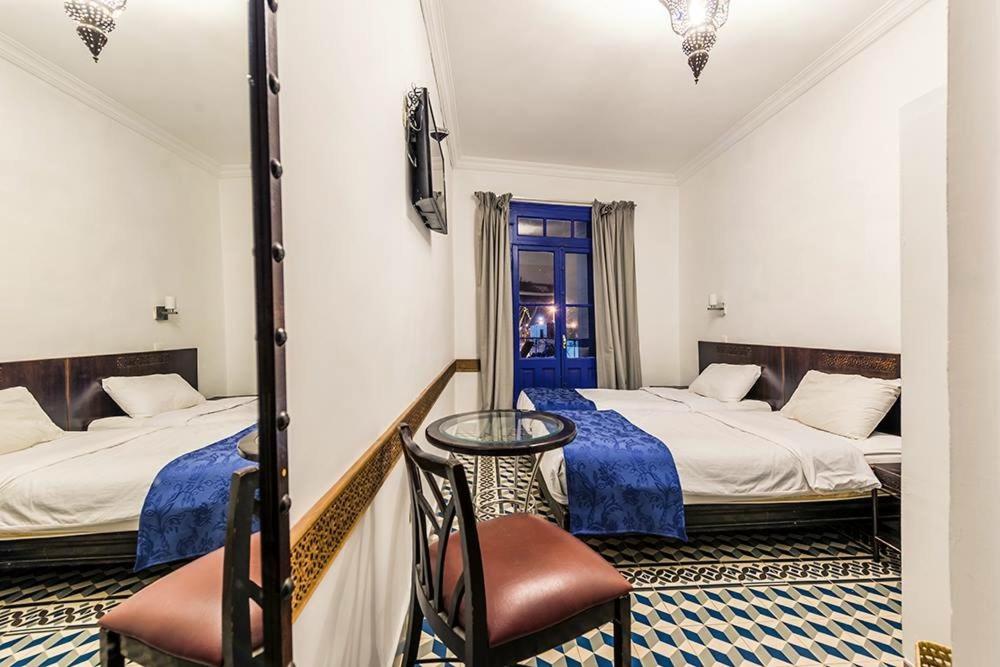 卡萨布兰卡中心酒店的酒店客房,配有两张床和椅子