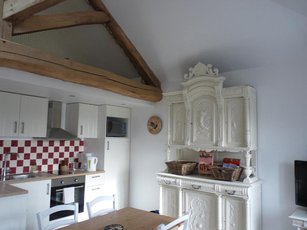 Orgerus乐塔贝尔德奥尔格尔斯度假屋的厨房配有白色橱柜和桌椅