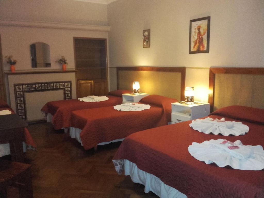 萨尔塔Posada La Casona的酒店客房,配有三张带红色床单的床