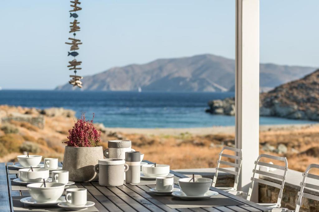 基斯诺斯Eneos Kythnos Beach Villas-Elegant and Comfort Villas的桌子上摆有杯子和碟子的桌子