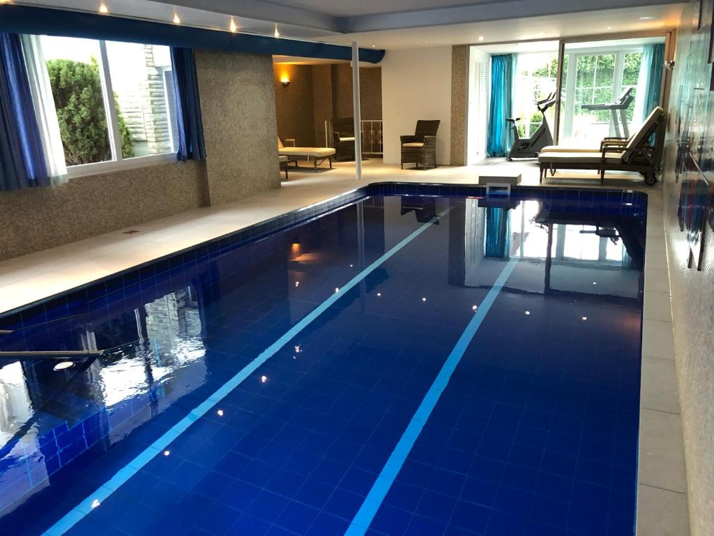 巴特利普施普灵格舍夫酒店的大楼内一个蓝色瓷砖的大型游泳池