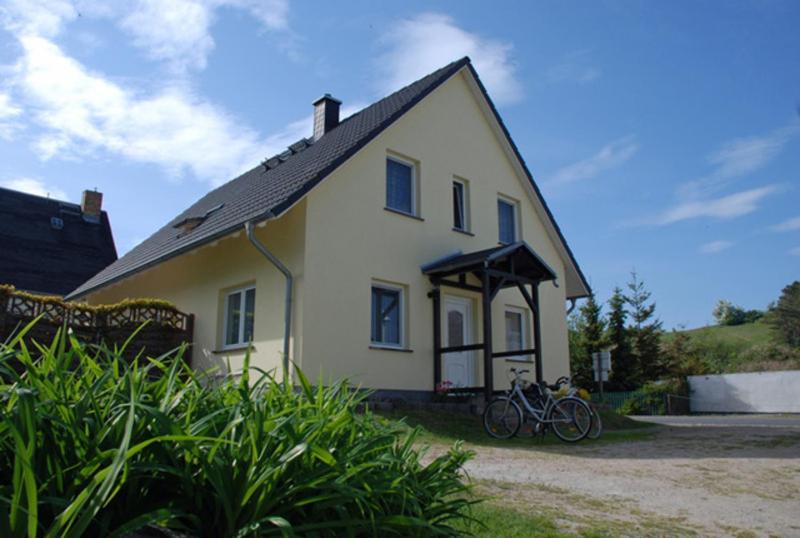 Klein ZickerFerienwohnungen Familie Looks的一辆白色的房子,前面停放着一辆自行车
