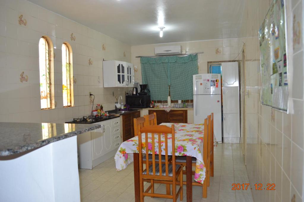 圣加布里埃尔Pousada M&J的厨房配有桌椅和冰箱。