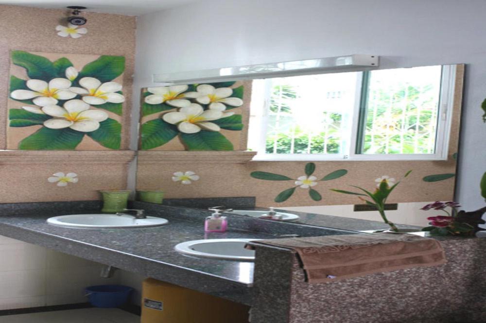 七岩查安裴斐科特民宿的浴室的墙上挂着两个水槽和鲜花