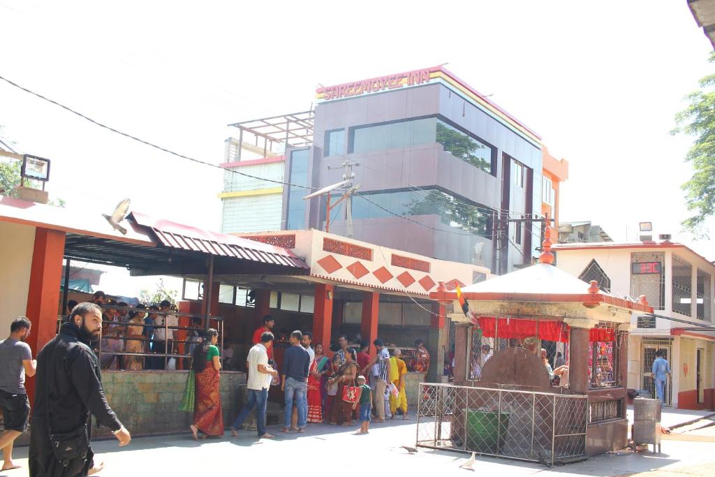 古瓦哈提Hotel Shreemoyee Inn - Kamakhya Temple的一群人站在建筑物外