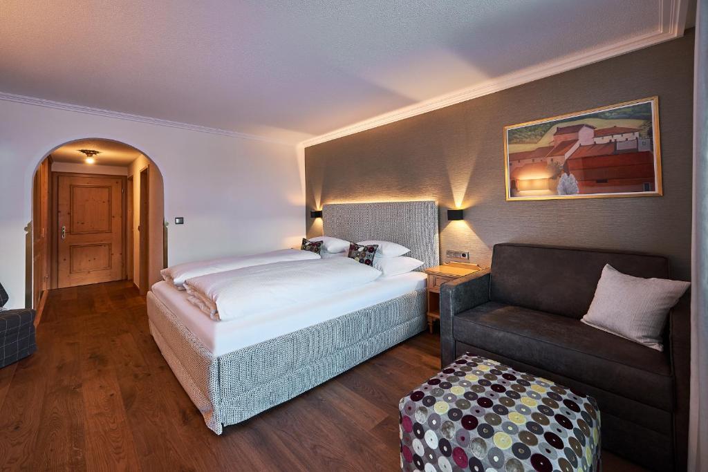 莱赫阿尔贝格加尼雪绒花酒店的一间卧室配有一张床和一张沙发
