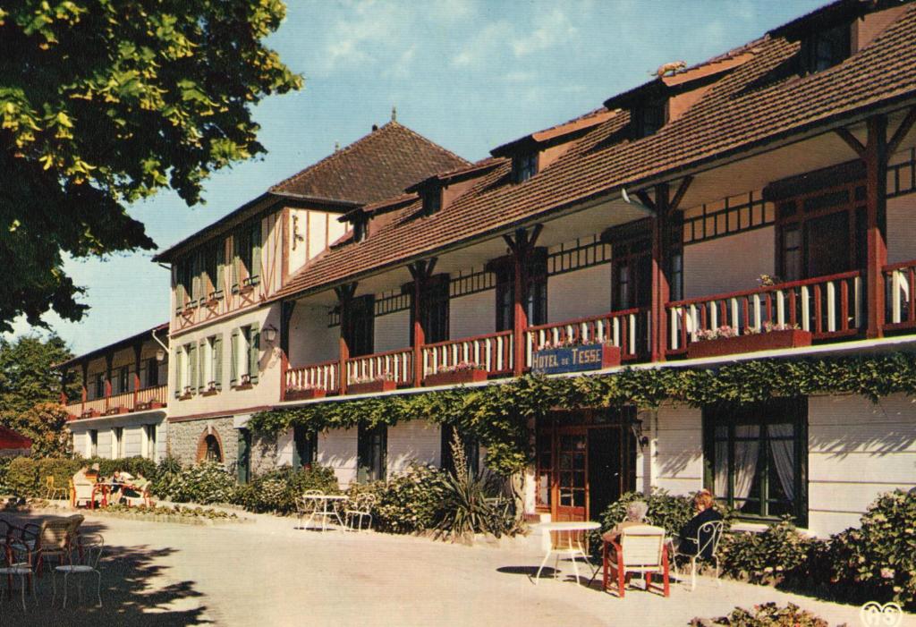 巴尼奥勒德日洛恩Hôtel de Tessé的一座大建筑前面设有桌椅