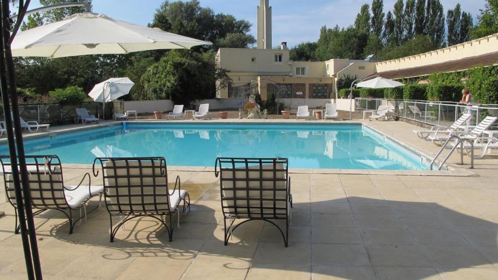 莫城阿克斯特尔酒店的一个带两把椅子和遮阳伞的游泳池