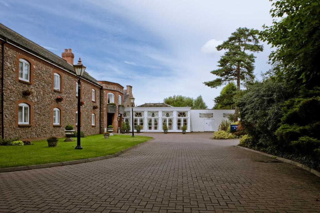 拉夫堡Quorn Country Hotel Leicester的大型砖楼前的车道