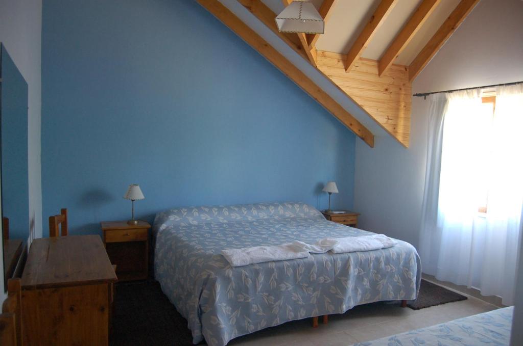 特来凡林拉艾斯丹诗酒店的一间卧室设有一张床和蓝色的墙壁