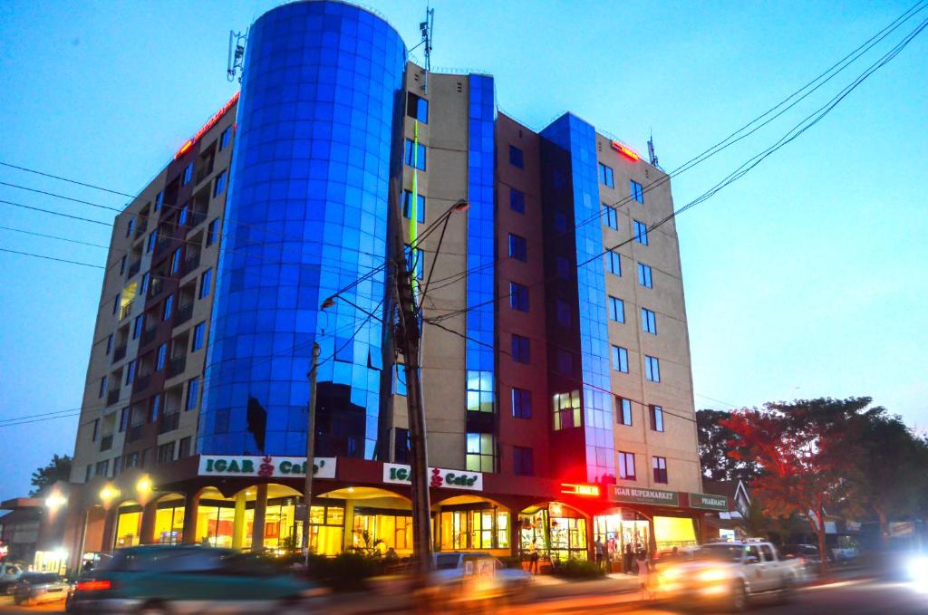 金贾Igar Plaza Hotel的建筑的侧面有蓝色的反射