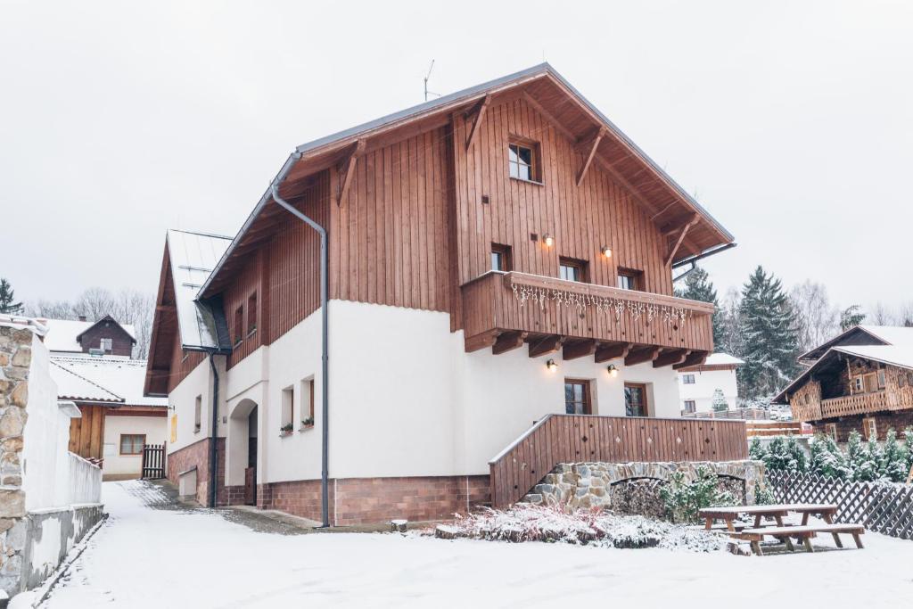 泽勒兹纳·鲁达卡普利茨基膳食酒店的一座木制建筑,在雪中设有阳台