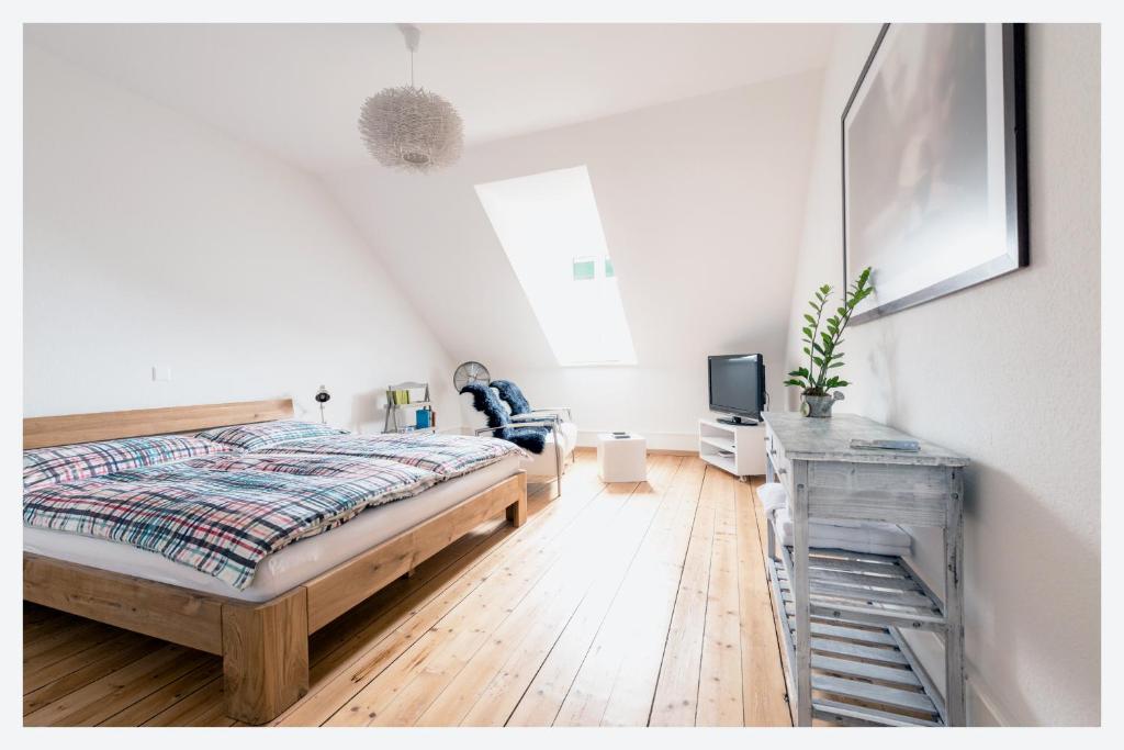 伯尔尼Bed & Kitchen am Tavelweg - Adults Only的一间卧室配有一张床、一台电视和一张书桌