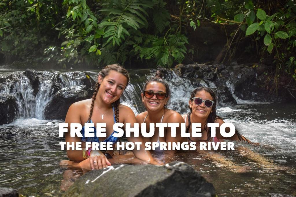 福尔图纳Hotel La Choza Inn的三人在瀑布里,乘坐免费班车前往免费温泉河