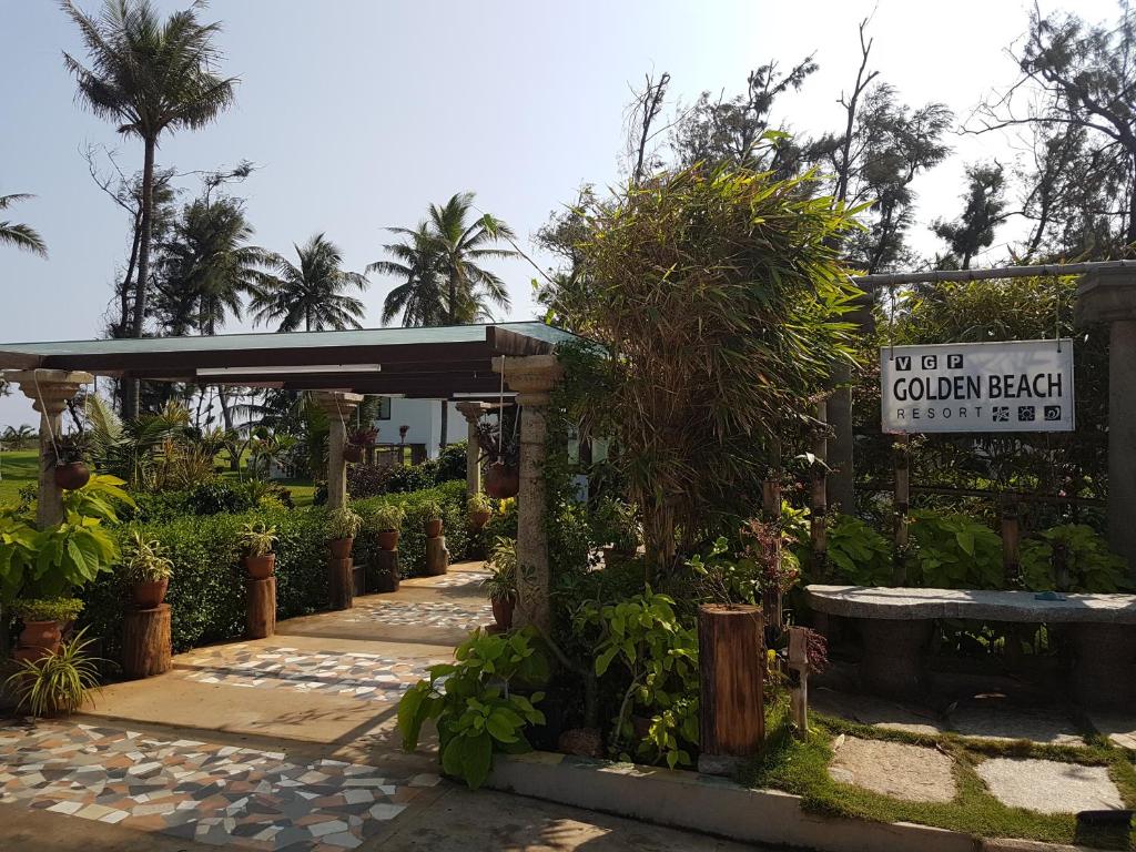 钦奈VGP黄金海岸度假酒店的花园凉亭,带有标志和一些植物
