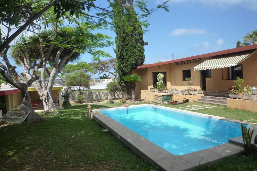 Valle de GuerraLagarto Hostel Tenerife的一个带游泳池和房子的后院