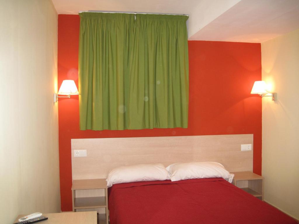 甘迪亚公爵旅馆的一间卧室设有绿色窗户和红色的墙壁