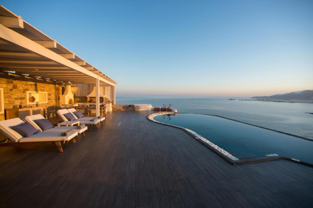斯泰里达Naxos Rock Villas的一个带无边泳池和大海的度假胜地