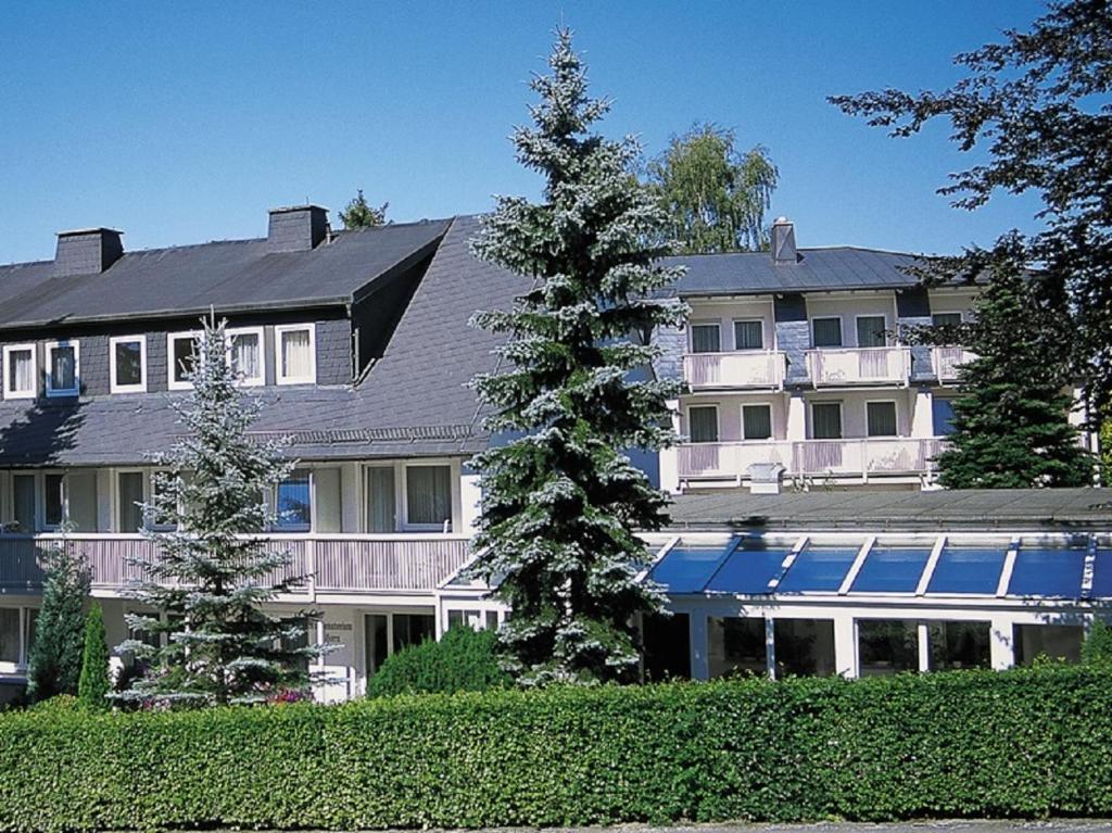 巴德斯特本Horn's Gästehaus的前面有树木的大白色房子