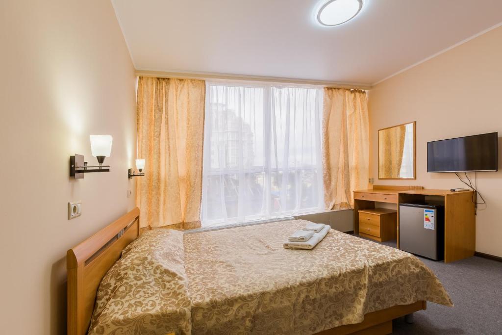 索契VeryHotel的酒店客房设有一张床和一个大窗户