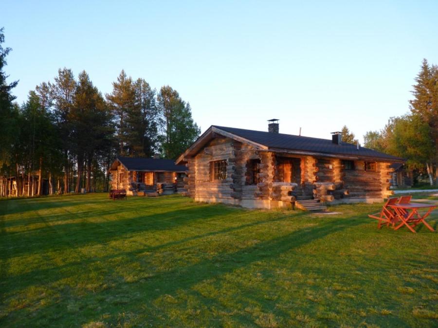 KarhujarviKarhujärven Kelopirtit的田野上的小木屋,有大院子