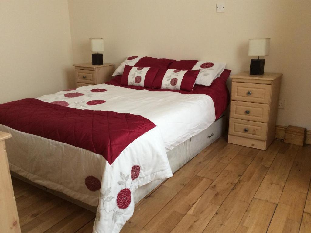 CarrigallenBridgefield House的一间卧室配有一张红色和白色的棉被床