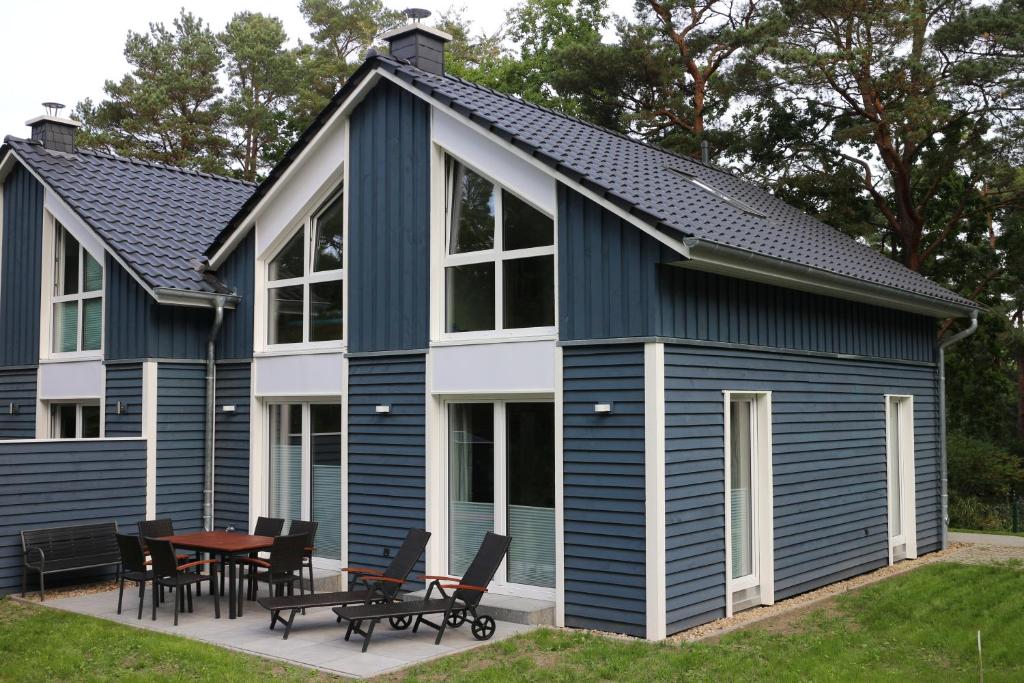 巴贝Strandhus Baabe Haus 3的蓝色和白色的房子,配有桌子和椅子