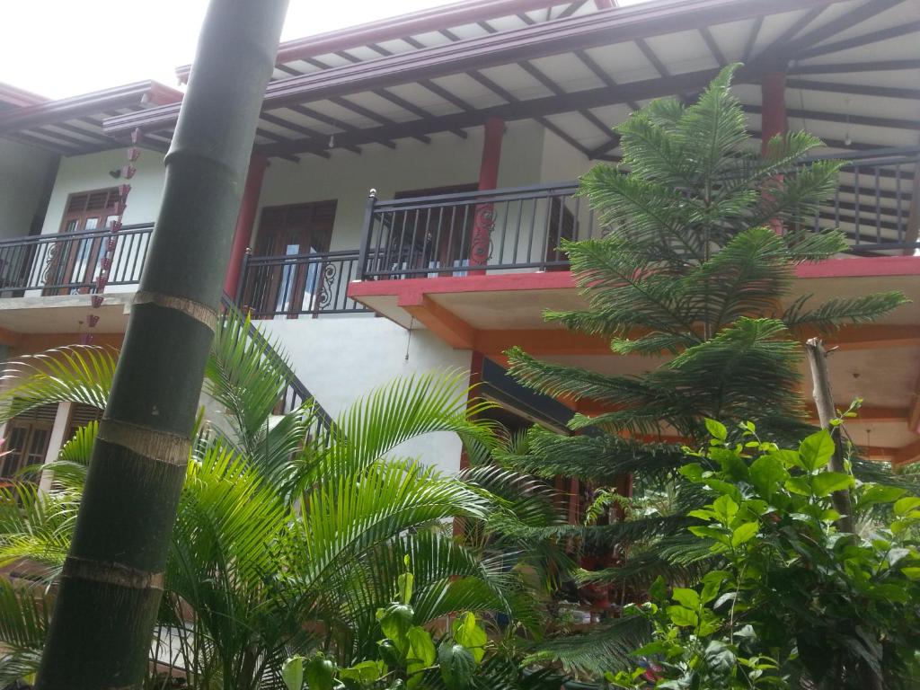 达瓦拉维孔雀别墅度假村的一座建筑前有棕榈树的建筑