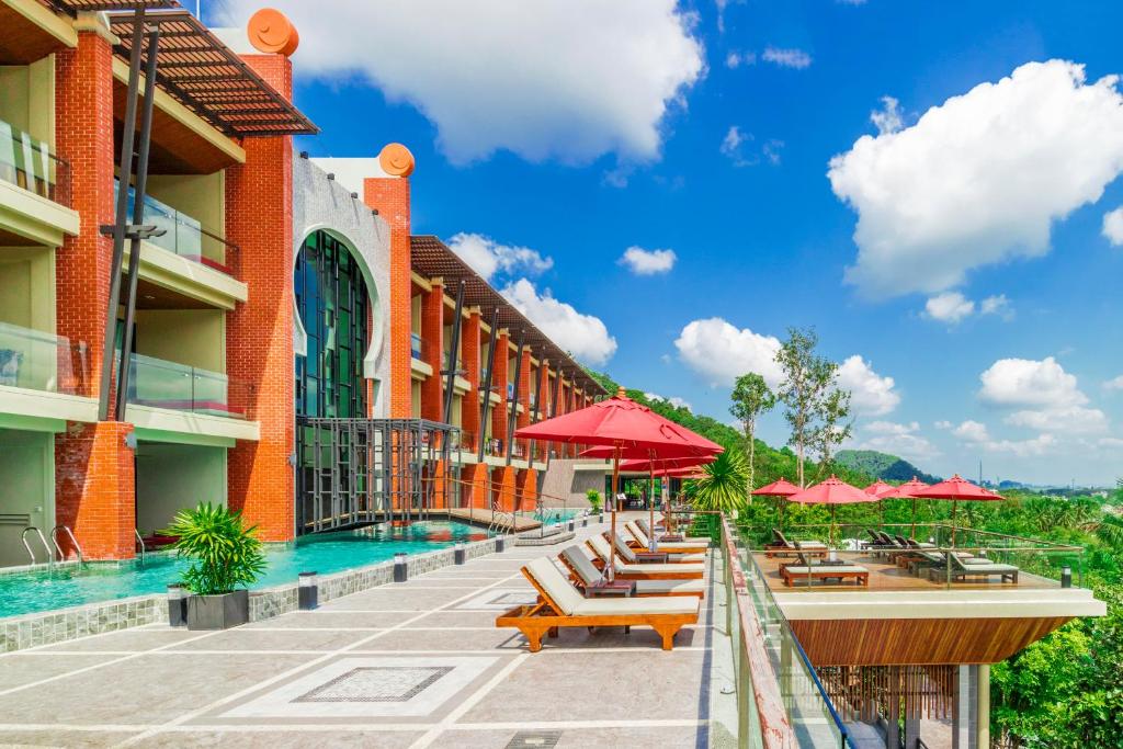 奥南海滩Aonang Phu Pi Maan Resort & Spa - SHA Extra Plus的一个带游泳池、椅子和遮阳伞的酒店