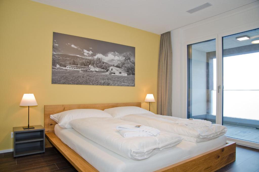因特拉肯Apartment Silberdistel - GriwaRent AG的一间卧室配有一张带白色床单的大床